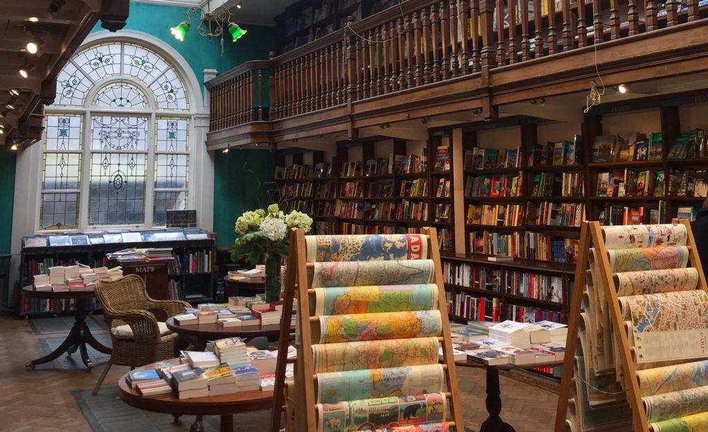 Reading - Daunt Books. A big picture window at the end of a room lined with lots of books.