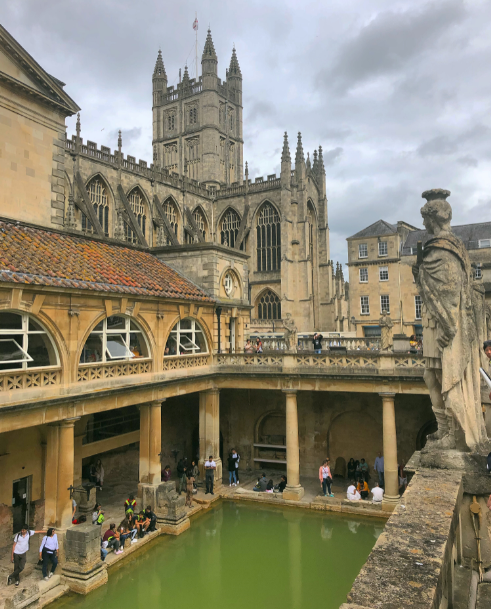 The Roman Baths in Bath - green water, the cathedral in the background.