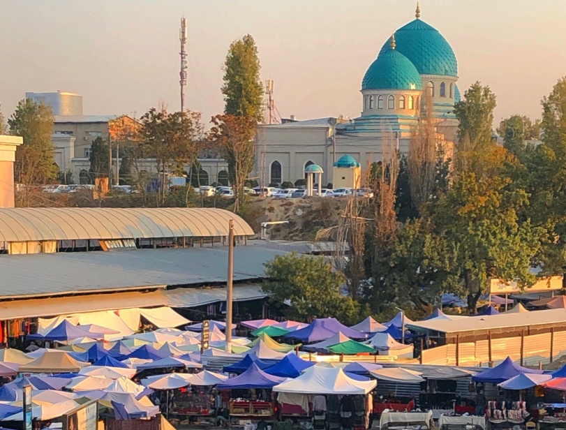 October 2019 - a view across the Chorsu Bazaar towards a building with turquoise domed roofs.