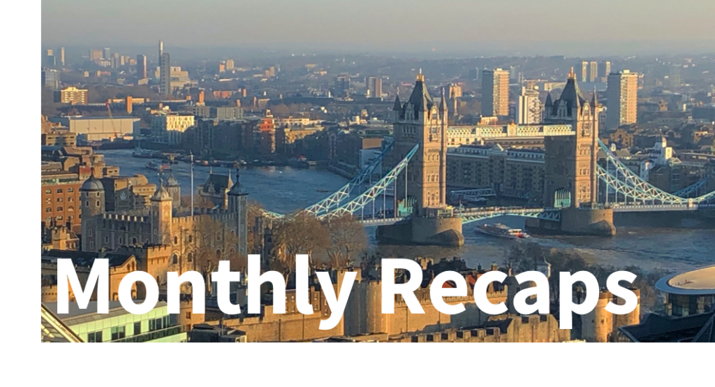 Blog Reviews: Monthly - text overlaying an image of Tower Bridge from afar, with a boat going underneath and a lot of other buildings surrounding it. 