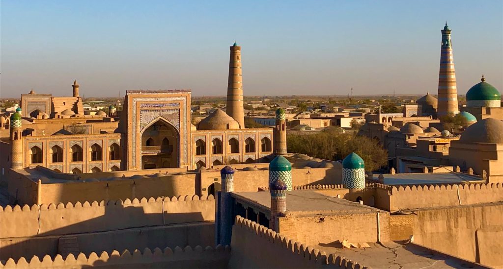 travel when not travelling - view across Khiva - city glowing in the late afternoon sunshine, all sand coloured, spires and domes.