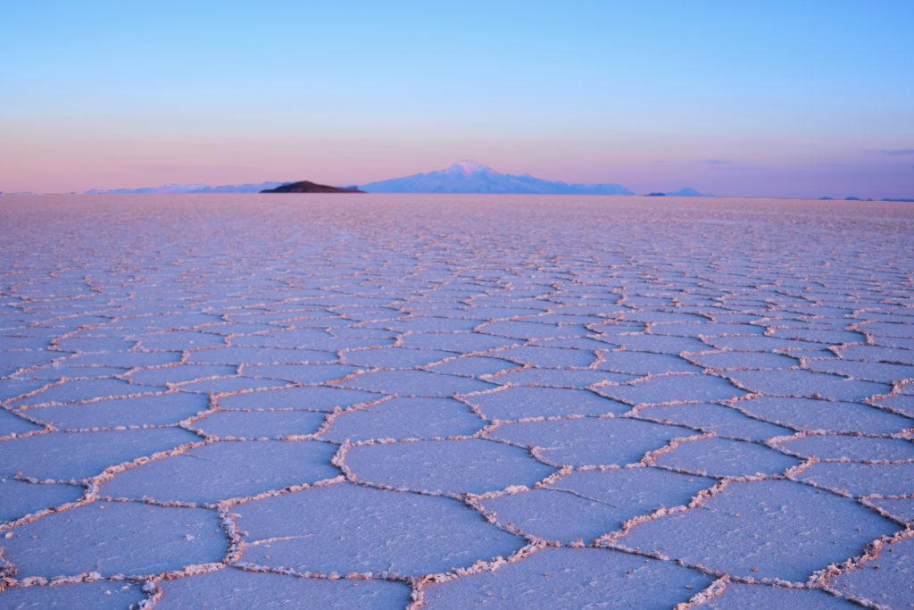 Bucket list. Pink and blue skies overhead, reflecting a little on the salt pan below which has taken on a pink hue. 