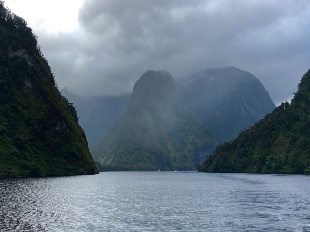 Doubtful Sound. Clouds and mist obscure the mountains that plunge down to the water below.