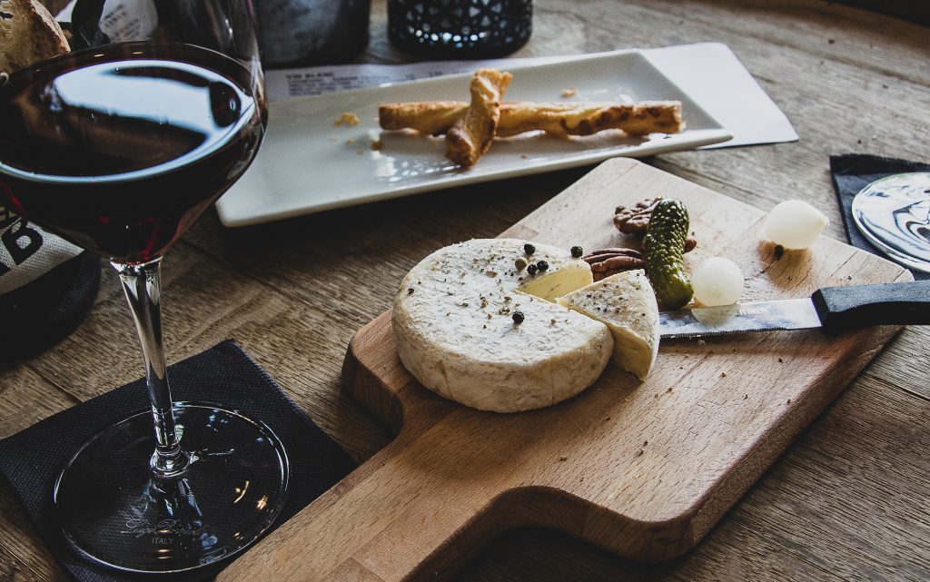 Lockdown loves - a cheese board featuring pickles and a glass of wine.