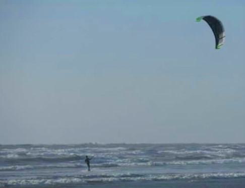 A single kite surfer in the waves